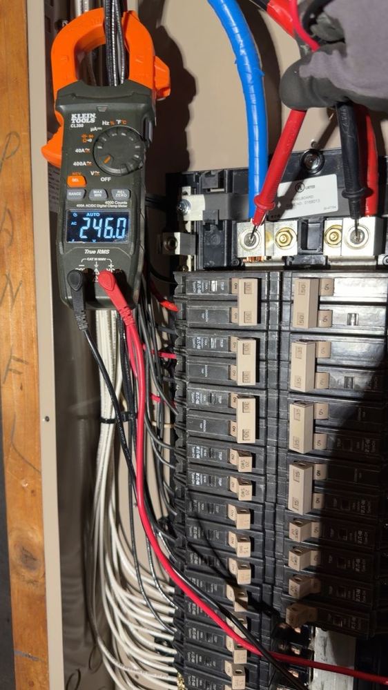 Electrician verifying 246 volts with clamp meter